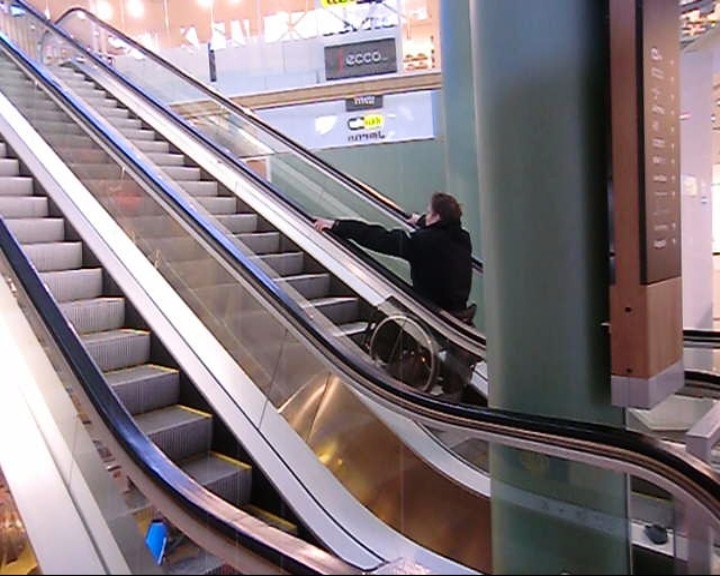 User rides up an escalator. 
